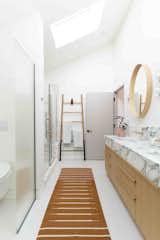 sunlight filled bathroom with tile floor and runner