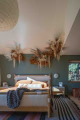 a bedroom with dried flower artwork on the wall