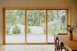 A 12-foot-tall wood-clad multi-slide door in the open plan living-dining room offers an ocean view.
