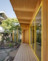 Cedar siding clads the building's garden-facing facade and eaves over the wraparound porch and will turn silver over time.