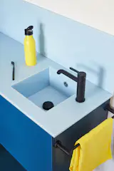 The homeowner chose the sky blue composite countertop and backsplash, which helps build the apartment’s playful palette.