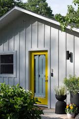 Howmeowner and designer Ghislaine Viñas painted the glass front door's frame in Benjamin Moore's lemon-y hue, Baby Chick. Her graphic designer husband Jaime created the numerical graphic that also serves as a privacy screen.