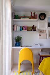 A vintage chair sits at the desk in the bedroom, which is decorated with a collage of artworks, including a hand-drawn floor plan of the house from the previous owners.