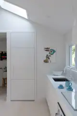 The kitchen wall was moved forward to host a built-in fridge and enlarge the bathroom behind it.