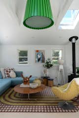 The colorful living room features a rug by Ghislaine Viñas for the Rug Company and an artwork by Mark Mulroney.