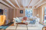 The living room requires minimal lighting, thanks to its expansive windows.