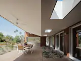 The angled roof over the new fitness room extends to cover the outdoor kitchen and dining room, but is punctured by strategically placed skylights.