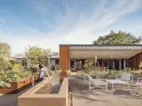 A recirculating water feature adds atmosphere to the backyard with its edibles garden, Hay patio set, and outdoor kitchen and dining room, the latter protected from the sun by an extension of the home's eaves.