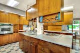Kitchen, Pendant Lighting, Wall Oven, Cooktops, Refrigerator, Dishwasher, Ceramic Tile Floor, Wood Cabinet, Ceiling Lighting, Drop In Sink, and Microwave  Photo 14 of 65 in Marvelous Mid-Century Modern by Pat Shannon