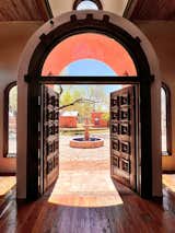 The main entrance welcomes guests with rustic wood relief designed Spanish doors.