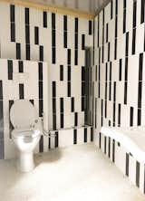 Bath Room, Tile Counter, Ceramic Tile Wall, Cement Tile Floor, One Piece Toilet, Wall Lighting, Wall Mount Sink, and Wood Counter  Photo 1 of 8 in Workshop by Studio 3Mark