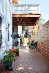 Outdoor, Horizontal Fences, Wall, Walkways, Shrubs, Large Patio, Porch, Deck, Decking Patio, Porch, Deck, Raised Planters, Trees, Side Yard, and Wood Fences, Wall Outdoor living alongside the narrow house  Photo 3 of 10 in Baymiller Renovation by Hayes Shanesy