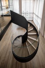 Staircase, Metal Tread, Wood Tread, and Glass Railing Metal spiral staircase   Photo 7 of 22 in The Black Silhouette Apartment by ORKO STUDIO