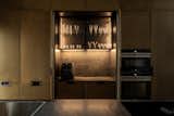 Kitchen, Cooktops, Microwave, Engineered Quartz Counter, Medium Hardwood Floor, Metal Cabinet, and Wall Oven Kitchen Area   Photo 11 of 22 in The Black Silhouette Apartment by ORKO STUDIO