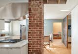 Kitchen, Dishwasher, Marble Counter, Range Hood, Refrigerator, Cooktops, Marble Backsplashe, White Cabinet, Light Hardwood Floor, Ceiling Lighting, and Drop In Sink  Photo 11 of 28 in South House by Giaimo