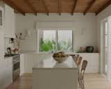 Kitchen, Wall Lighting, Range Hood, Cooktops, Ceiling Lighting, Marble Counter, Undermount Sink, White Cabinet, Medium Hardwood Floor, and Stone Slab Backsplashe Kitchen  Photo 5 of 8 in Casita M by Emily Evans