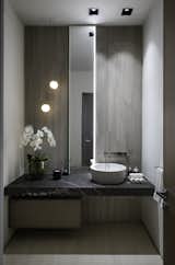 This neutral powder room has high end fixtures, bespoke cabinetry and custom lighting.