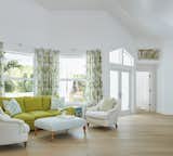 Draperies made of Schumacher’s Tropique fabric frame a sitting area near the entryway. We covered the Lee Industries armchairs in linen, sofa in Vanguard Furniture’s Venue velvet in Quince and ottoman in a Rogers & Goffigon textile. 