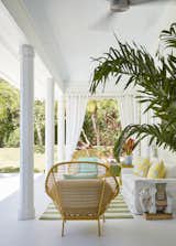 West Elm’s Paradise lounge chairs join a Lee Industries sofa—topped with pillows from Patrick Day— by a Pottery Barn rug on the loggia The Sunbrella draperies close when desired.