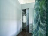 The walk-in wardrobe, placed behind the bed, is well organized and makes the best possible use of the space with shelves and fixtures for hanging clothes.