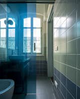 The wall covering in the bathroom, which decorates the walls with graphic patterns, is made up of 15x15 square tiles placed in four bands of four different shades of green, ranging from the darkest at the bottom to the lightest at the top.