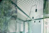Pendant lights are hung from the metal mesh ceiling of the four-poster bed and they can be moved wherever more light is needed. 