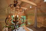 The Barn at Edenwood's loft area is an elegant and modern oasis with a mixture of reclaimed pieces (like the antique chandelier) and modern 150 gallon round tub (photo credit Aerial Photo Pros)