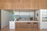 Kitchen, Ceramic Tile Backsplashe, White Cabinet, Light Hardwood Floor, Cooktops, Wall Oven, Engineered Quartz Counter, Refrigerator, Ceiling Lighting, Recessed Lighting, Range Hood, and Drop In Sink Kitchen  Photo 8 of 10 in Peka Peka House II by Herriot Melhuish O'Neill Architects