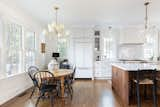 Kitchen, Range Hood, Ceramic Tile Backsplashe, Refrigerator, Ceiling Lighting, Dishwasher, Range, Medium Hardwood Floor, White Cabinet, Pendant Lighting, and Engineered Quartz Counter Brand new kitchen blending historic charm with all the modern conviences, including integrated Sub-Zero fridge  Photo 7 of 27 in Durham Historic Renovation on Dacian by Dan Ryan