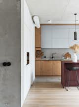 Kitchen, Concrete Counter, Colorful Cabinet, Wood Cabinet, Microwave, Light Hardwood Floor, Pendant Lighting, Ceiling Lighting, Drop In Sink, and Concrete Backsplashe  Photo 3 of 25 in Love Apartment by Liubov Lazoriv