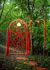 The metal railing that runs around the whole plot - including the metal gate at the entrance, a homage to the couple's dog, Lusia - is made with steel powder coated in the signature raspberry red color of the house.  Photo 10 of 11 in A Bright-Red Tiny Home Blossoms in Warsaw