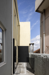 Since there is no space for a washing machine inside the house, this exterior cabinet was built to house the washing machine and provide some extra storage space. Meanwhile, the bathroom was moved upstairs as an en-suite to the bedroom.  Photo 5 of 14 in Before & After: In Porto, a Tiny Home Emerges From Ruins