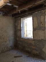 The original house had a narrow kitchen with a door at one end and a narrow living room with a window at one end. The two spaces were separated by a wall.  Photo 8 of 14 in Before & After: In Porto, a Tiny Home Emerges From Ruins
