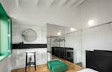 The use of mirrors on the upper floor serves to visually amplify the small space. Storage space is extremely limited in the tiny home, there is a clothes rack, and a green box which doubles as a drawer.