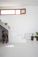 A built-in staircase leads up to the "bedroom", set on a sitting-height mezzanine level that fits a double bed (two standard-size IKEA 35-inch mattresses) and two bedside tables. The window gives Geo and Zoe something they had always wanted—a view of the sea from their bed.