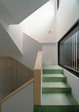 Staircase with rift-sawn white oak handrails and pour-in-place terrazzo in green.