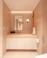 A cozy bathroom employs artisan mosaic/ceramic tiles that are locally made, while a comfortable experience is facilitated by a Japanese washlet, a climate control unit, and a slew of service products