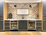 Kitchen, Wine Cooler, Wood Cabinet, Wall Lighting, Brick Backsplashe, Rug Floor, Engineered Quartz Counter, Light Hardwood Floor, Undermount Sink, and Beverage Center  Photo 5 of 7 in Exposed Brick and New Tile Lends a Modern Feel to This Ranch Remodel by Loren Wood Builders