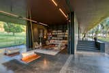 Living Room, Sofa, Coffee Tables, End Tables, Bookcase, Storage, Ceiling Lighting, Stools, Chair, Table, Lamps, Shelves, and Track Lighting Blurring of boundaries.  Photo 13 of 16 in Parikrama House by Spasm Design Architects