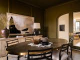 Dining room coated from head to toe in rich olive-green paint. Custom arched sliding glass doors create privacy while allowing natural light to come through. 