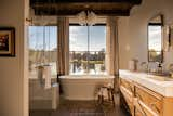 Primary ensuite with free-standing tub as the main focal point. Reclaimed wood-cladded ceilings create a statement. 