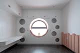 The bedroom for the 2 kids on the back of the 3rd floor is designed with a round window to catch the sunrise