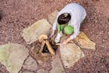 A new firepit blends into the pervious crimson stone  Photo 18 of 21 in La Croix House by Jennifer Martin