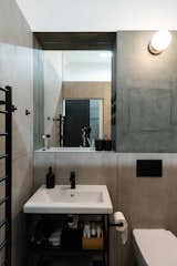 Bath Room, Wall Lighting, One Piece Toilet, Wall Mount Sink, Ceramic Tile Floor, and Concrete Wall Bathroom  Photo 16 of 23 in Apartment Renovation in Prague by Obliqo 