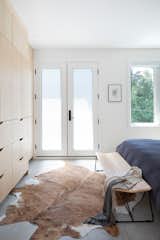 Custom millwork wall gives plenty of storage in the bedroom.