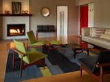 Finn Juhl japan chairs were reupholstered to bring the color scheme indoors.  A Thomas Hayes sofa sports custom pillows.  The round mirror is by Aksel Kjersgaard and was positioned to relate to the door frames which were stripped and walnut stained.
