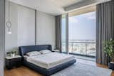 The master bedroom is extremely bare and minimalist with all the walls in a concrete texture