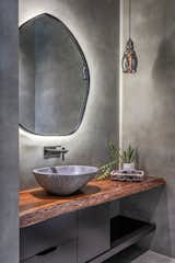 The powder bathroom which opens from the dining area is completely made of concrete finish tiles