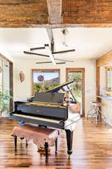 Piano salon with owner-designed and fabricated sculptural light fixtures, bar stools
