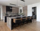 Kitchen featuring rift sawn white oak cabinets in a natural stain on the perimeter, ebony on the island. Italian marble countertops grace the full backsplash as well as a double waterfall detail on both island ends.  